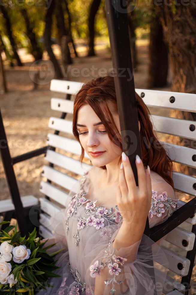 schön Braut mit Strauß Blumen steht auf Wald Hintergrund. rustikal Stil. schön Braut im zart Kleid draußen. schließen oben Porträt von jung Braut im Park im sonnig Wetter bewaldet Bereich. foto