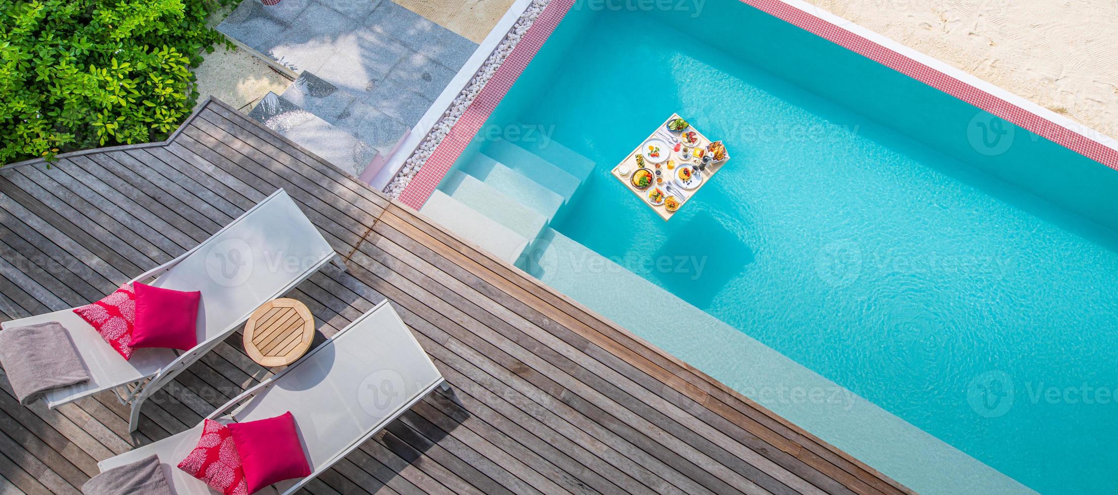 Frühstück im Swimmingpool, schwimmendes Frühstück im luxuriösen tropischen Resort. Tisch entspannt auf ruhigem Poolwasser, gesundes Frühstück und Obstteller am Pool des Resorts. tropisches paar strand luxus lebensstil foto