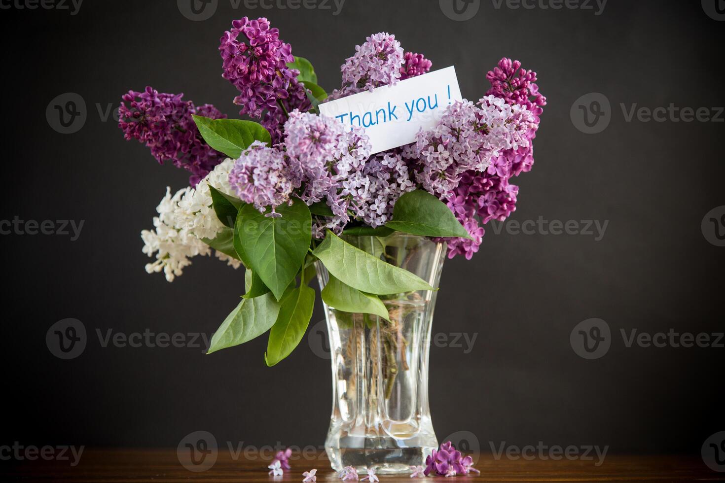 Strauß von anders Blühen Frühling Flieder im ein Vase auf schwarz Hintergrund foto