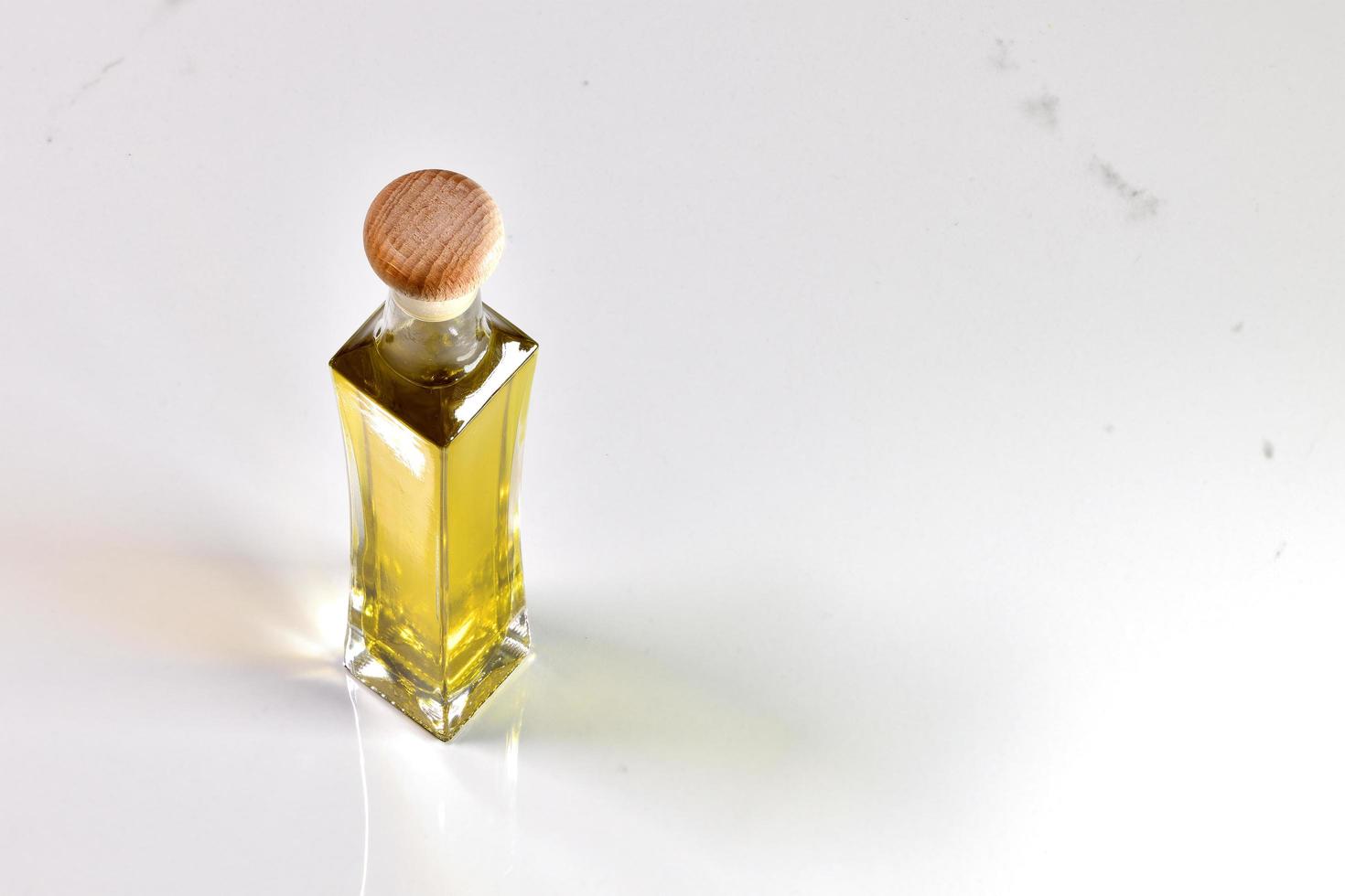kleine Flasche Olivenöl auf weißem Hintergrund foto