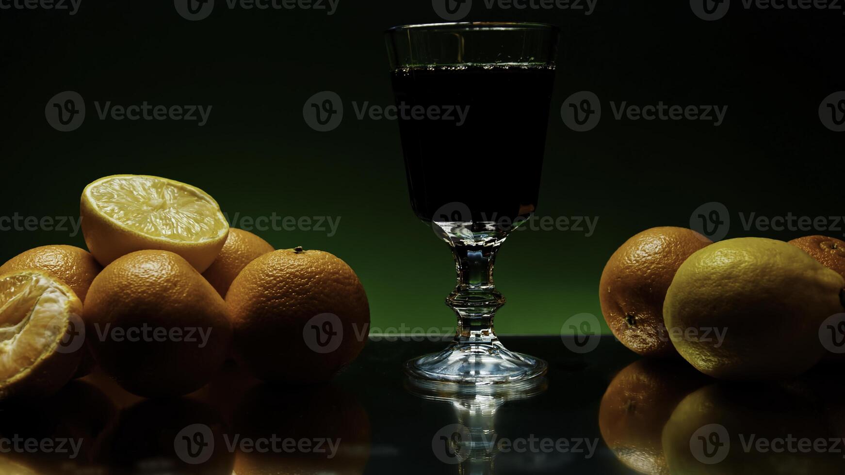 Rum trinken Sein gegossen in lange Glas, isoliert auf bunt beleuchtet Mauer Hintergrund. Lager Clip. Alkohol trinken auf das reflektierend Tabelle oder Bar Zähler mit Orange Früchte. foto