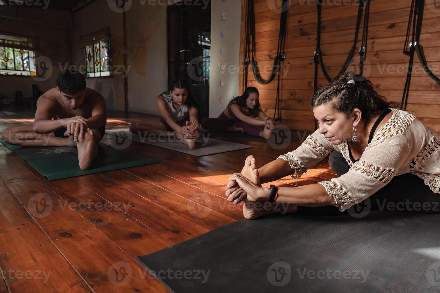 Frau Yoga Lehrer mit ihr Gruppe von Studenten Dehnen nach Klasse im das Yoga Zimmer. foto