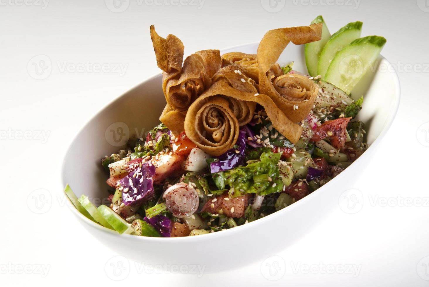 Köstlicher Fattoush oder arabischer Salat mit Pita-Croutons, frischem Gemüse und Kräutern, auf weißem Teller. orientalischer Brotsalat. einfaches und gesundes authentisches Rezept. foto