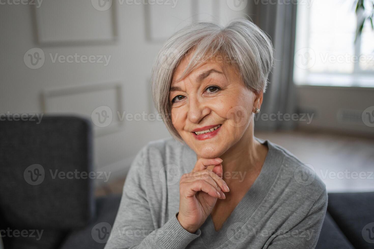 Porträt von zuversichtlich stilvoll europäisch Mitte alt Senior Frau. älter reifen 60er Jahre Dame lächelnd beim heim. glücklich attraktiv Senior weiblich suchen Kamera schließen oben Gesicht Kopfschuss Porträt. glücklich Menschen foto