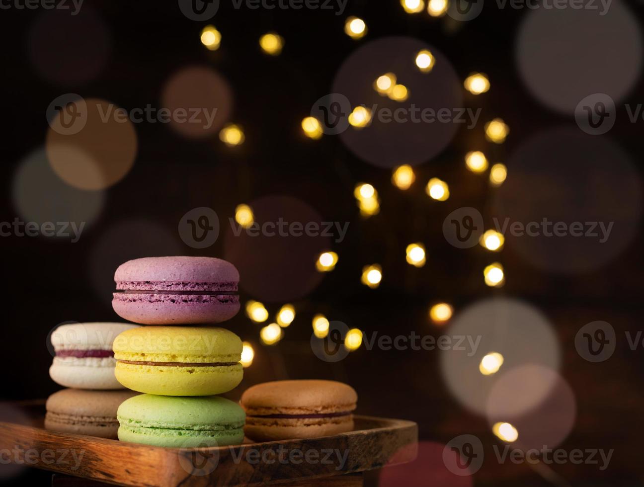 Stapel Makronen auf dem Tisch, Lichterketten und Bokeh-Hintergrund foto