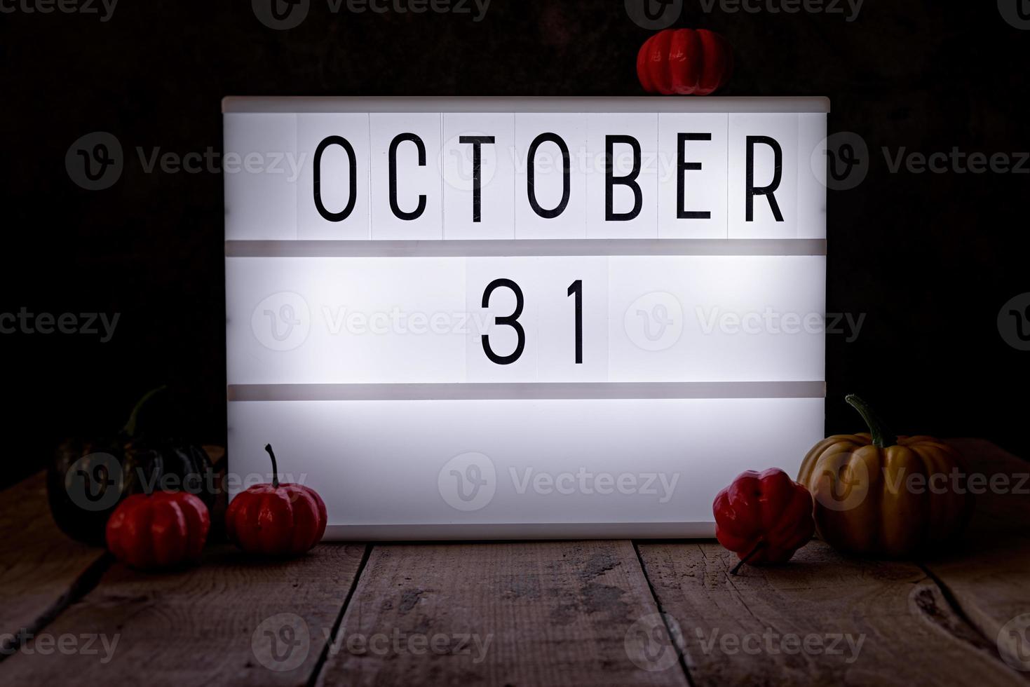 31. Oktober Leuchtkasten in der Dunkelkammer mit Kürbissen auf Holzboden foto