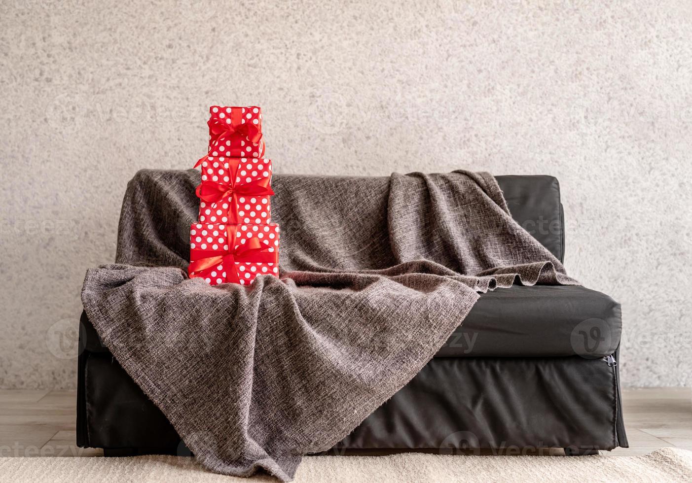 rote geschenkboxen auf grauem sofa im wohnzimmerinnenraum foto