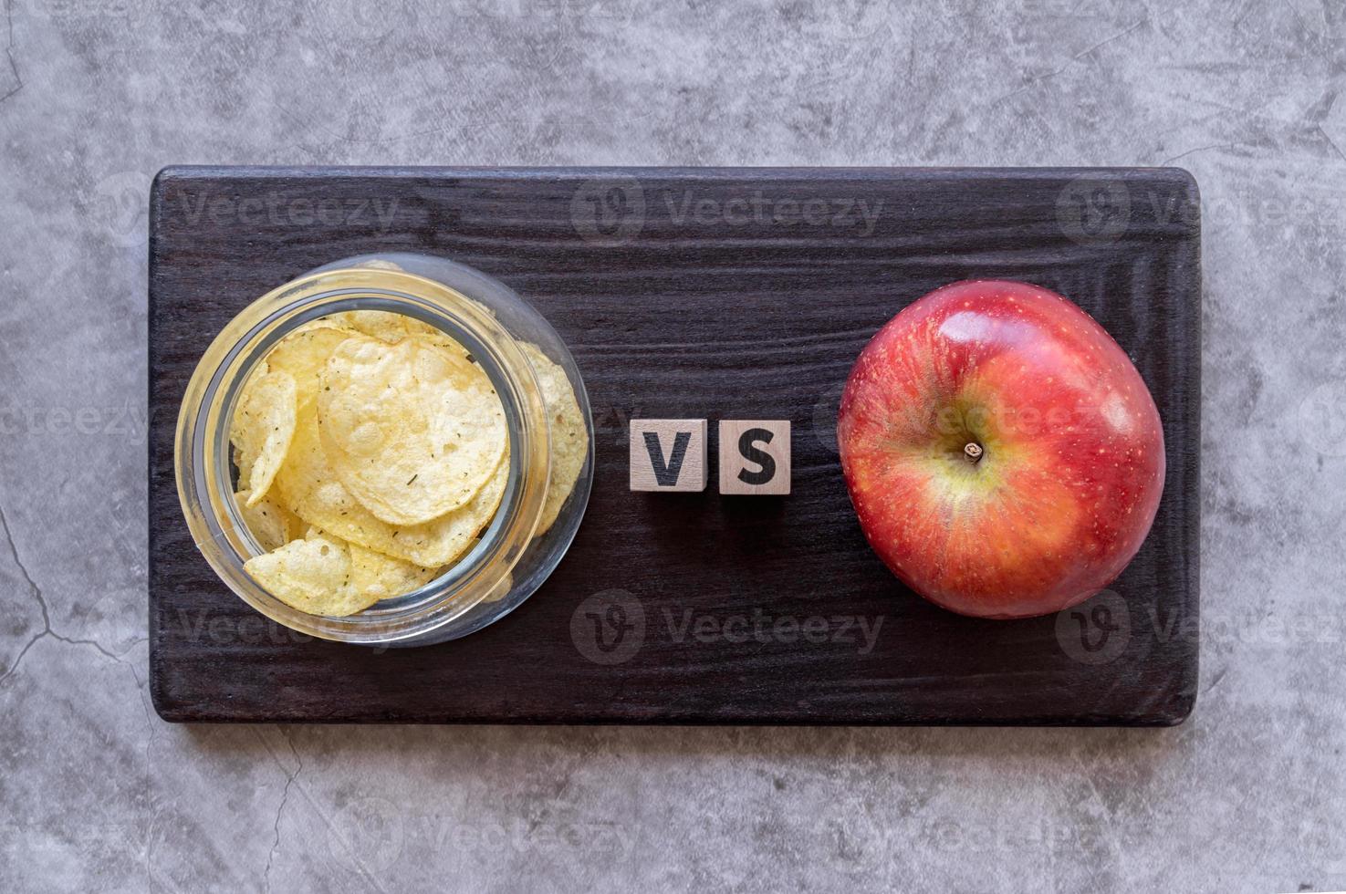 Chips versus Apfel-Draufsicht auf dunklem Hintergrund foto