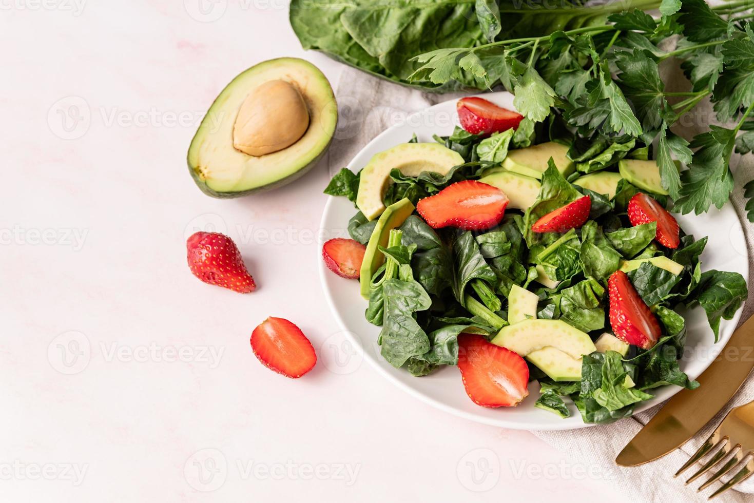 Avocado-, Spinat- und Erdbeersalat auf weißem Marmorhintergrund foto