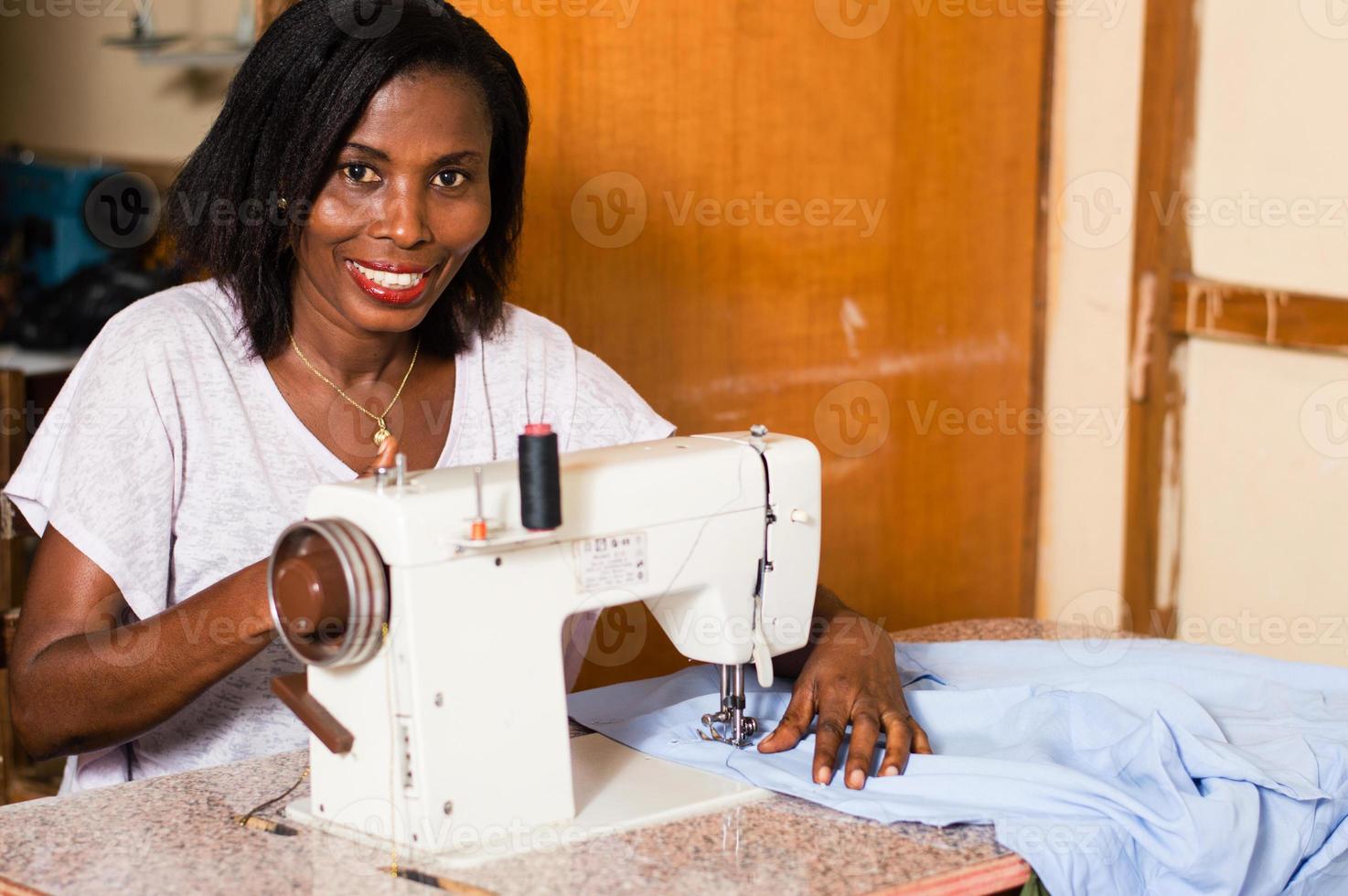 junge afrikanische frau, die in ihrem studio näht. foto