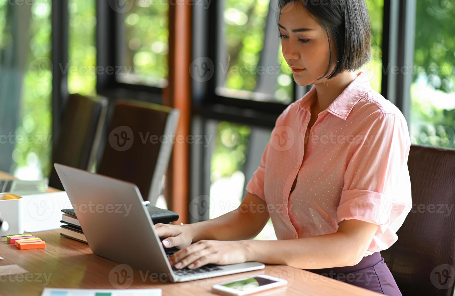 asiatische Teenager-Frau verwendet einen Laptop im Büro. foto