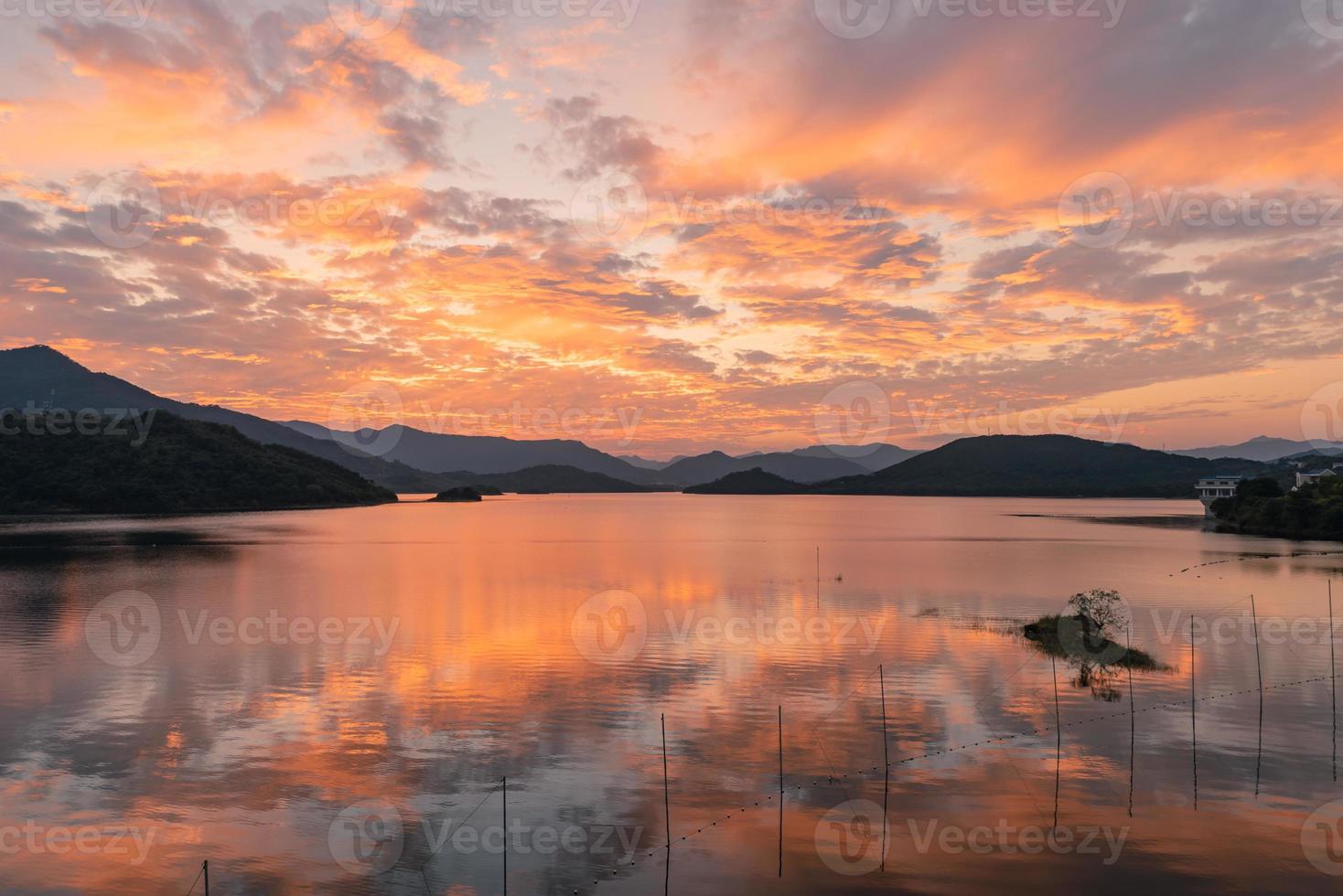 der abendsee reflektierte das sonnenuntergangsglühen und die berge foto