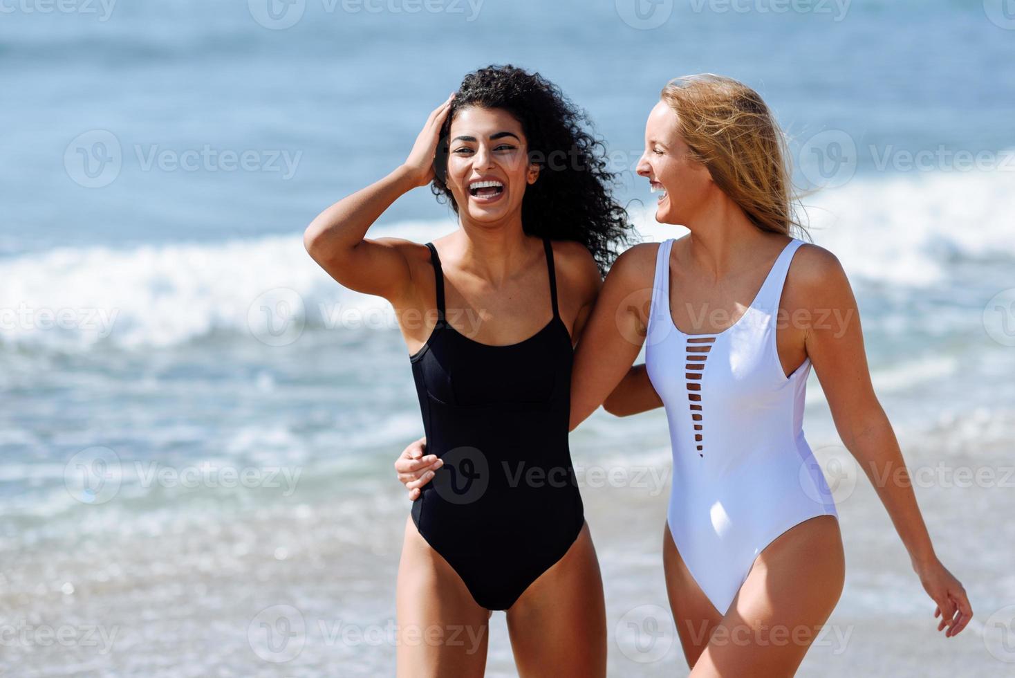 zwei junge Frauen mit schönen Körpern im Badeanzug an einem tropischen Strand foto
