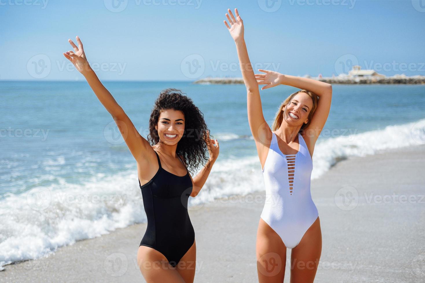 zwei junge Frauen mit schönen Körpern im Badeanzug an einem tropischen Strand foto