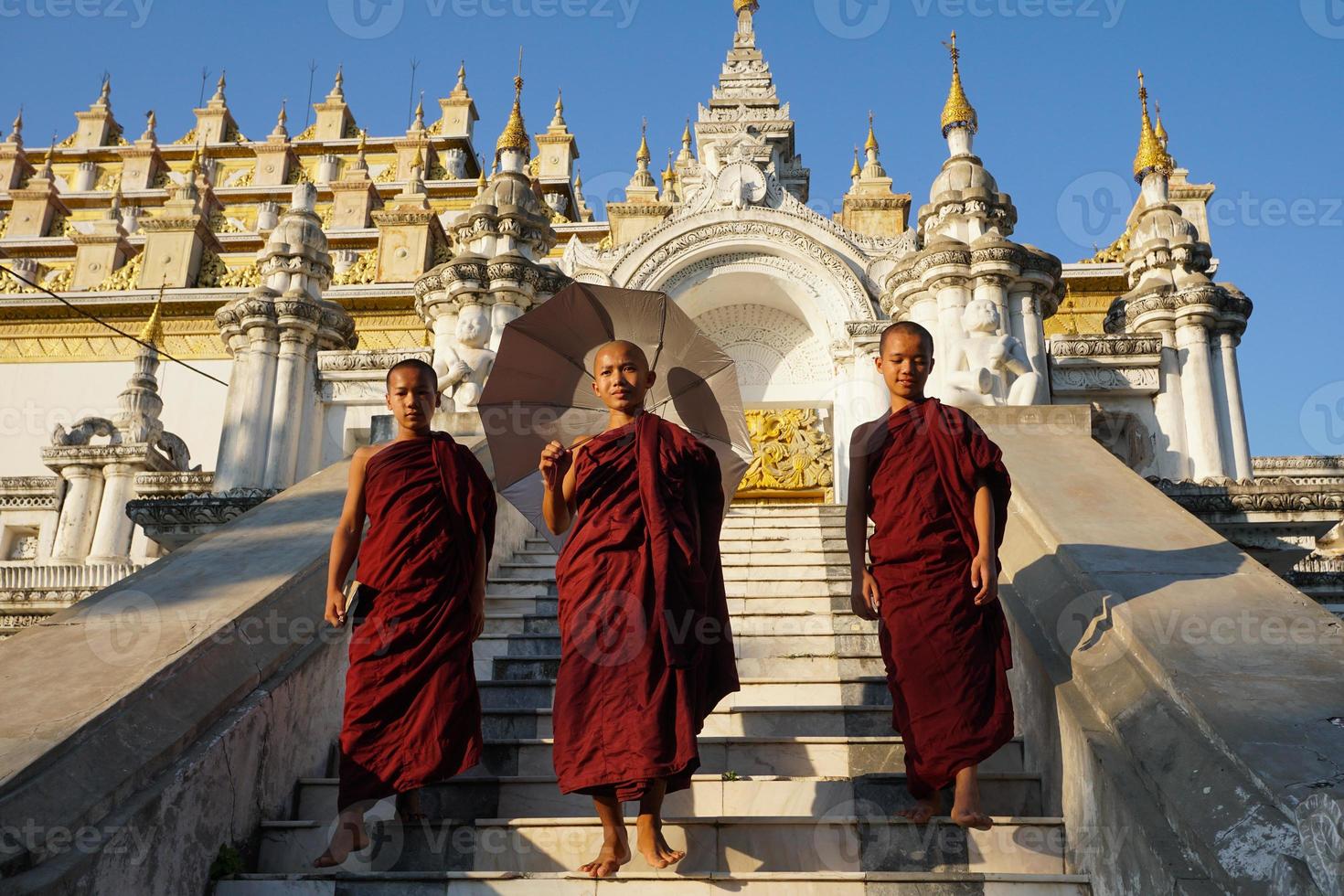 Gruppe asiatischer Novizen, die die Treppe des Klosters hinuntergehen foto