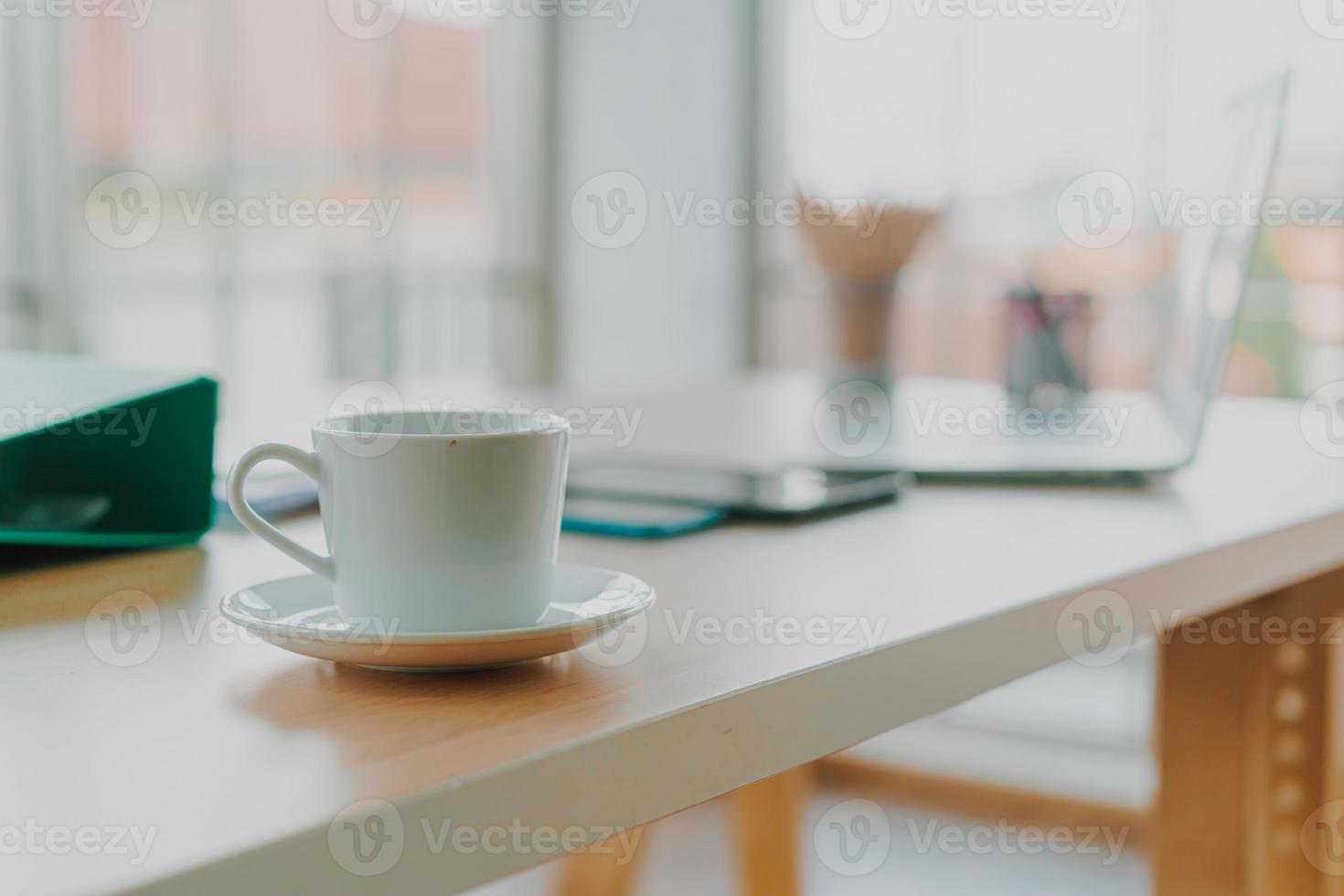 weiße Kaffeetasse auf dem Arbeitstisch foto