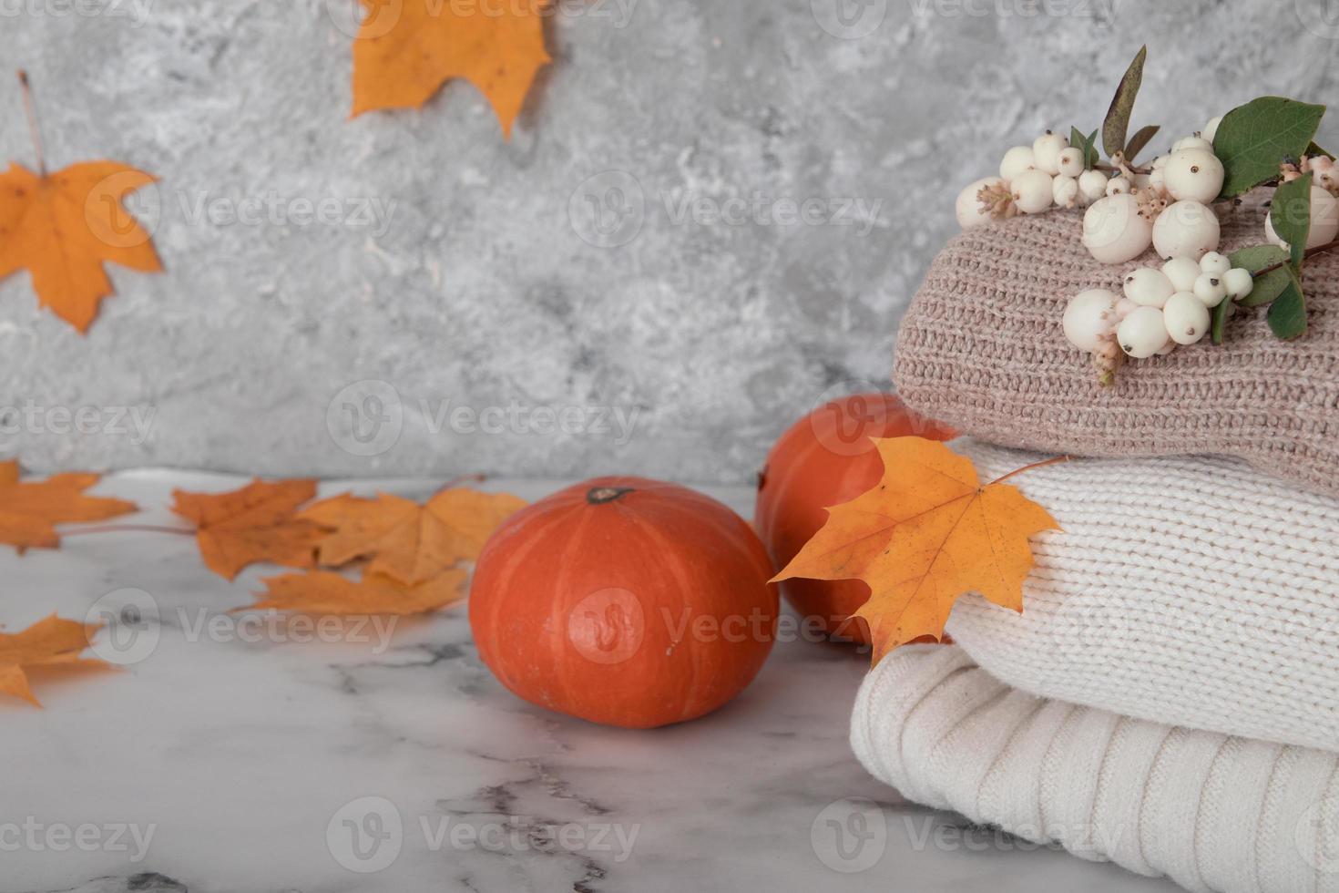 Herbststillleben mit Strickpullovern, Laub, Kürbissen. foto