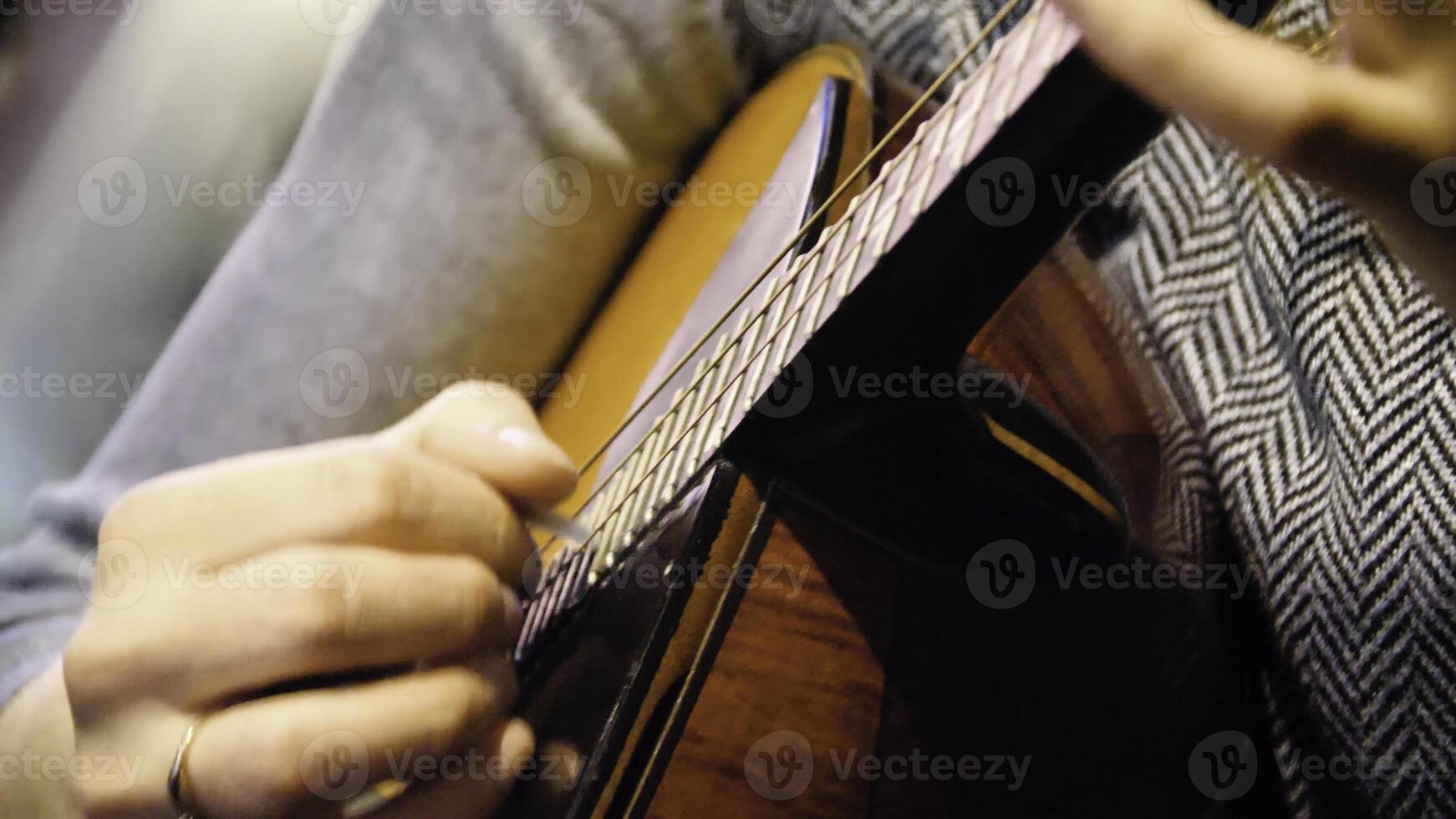 Nahansicht schön akustisch Gitarre Sein gespielt durch Frau Sitzung runter, Musiker Konzept. Frau spielen das Gitarre Nahansicht foto