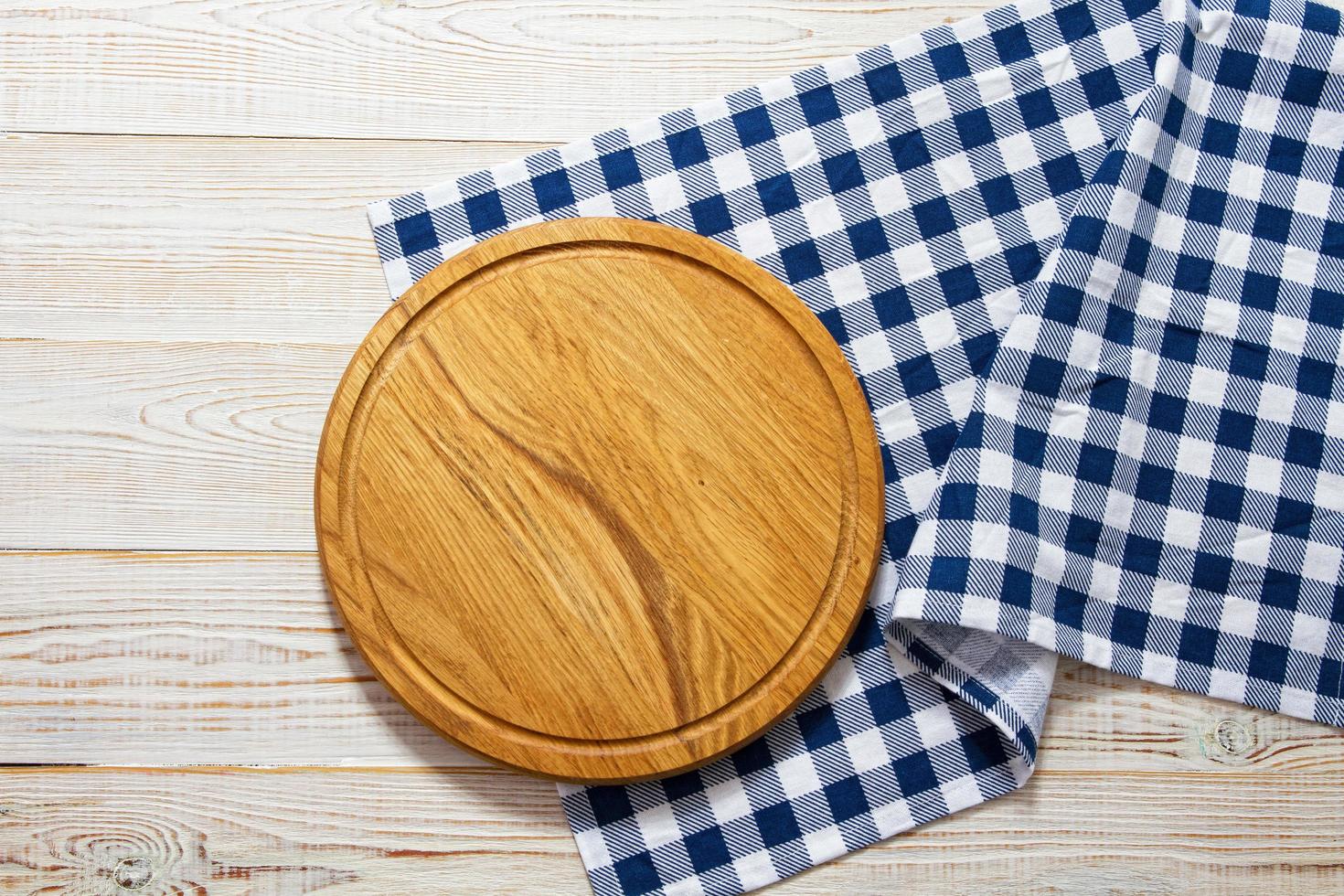 leere Holzplatte mit Serviette auf weißem Tisch, Draufsicht, Kopienraum. Holzschneidebrett auf weißem Betonhintergrund foto