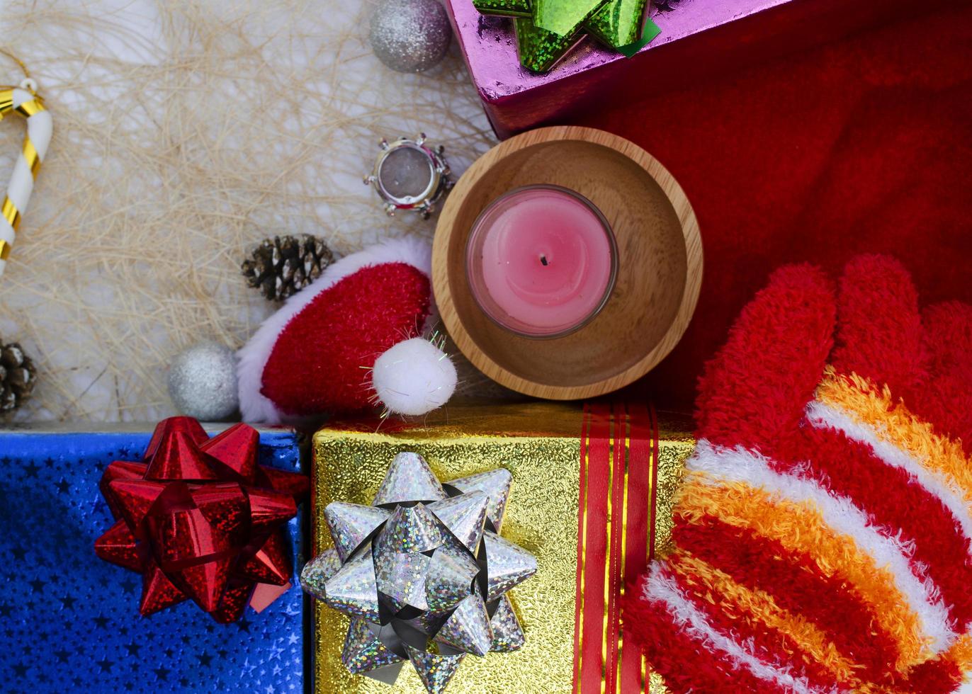Weihnachtsmütze und Kerze mit Geschenkboxdekorationshintergründen oben foto