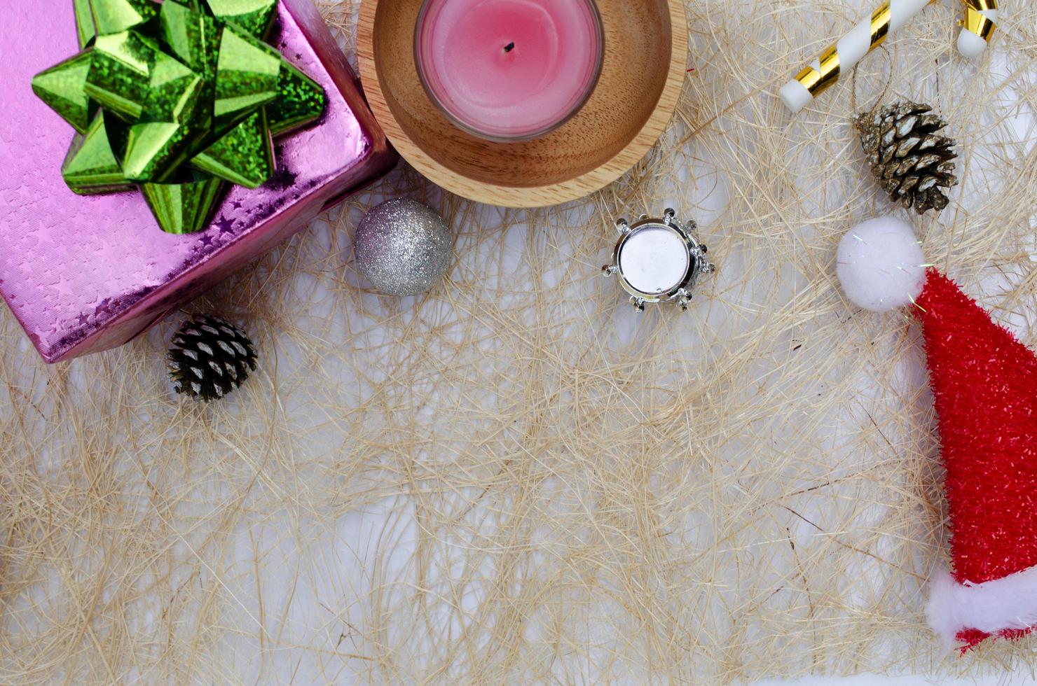 rosa Geschenkbox und Kerze mit Weihnachtshutdekorationshintergründen oben foto