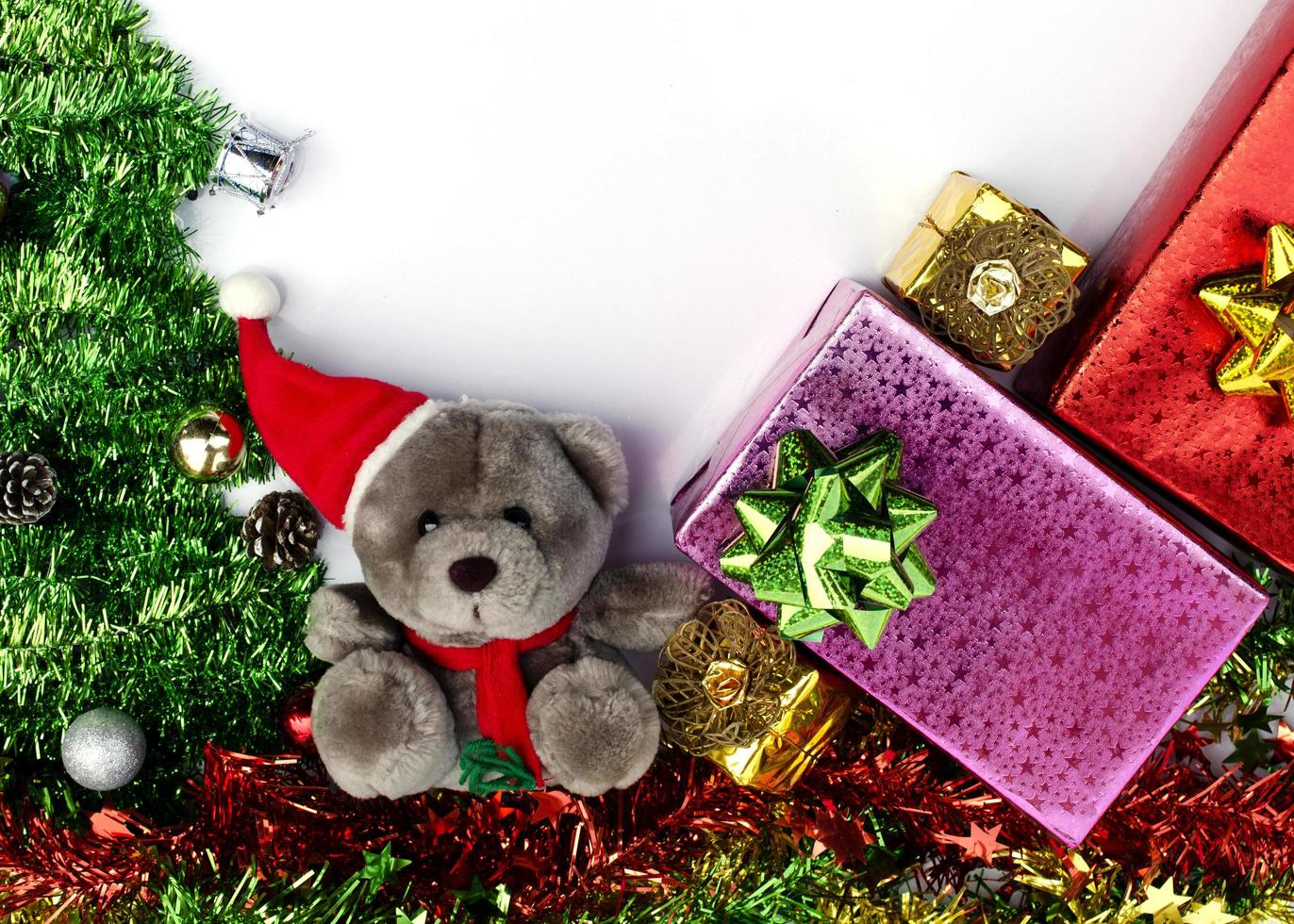 Teddy und Geschenkbox mit Weihnachtsdekoration auf weißem Hintergrund oben foto