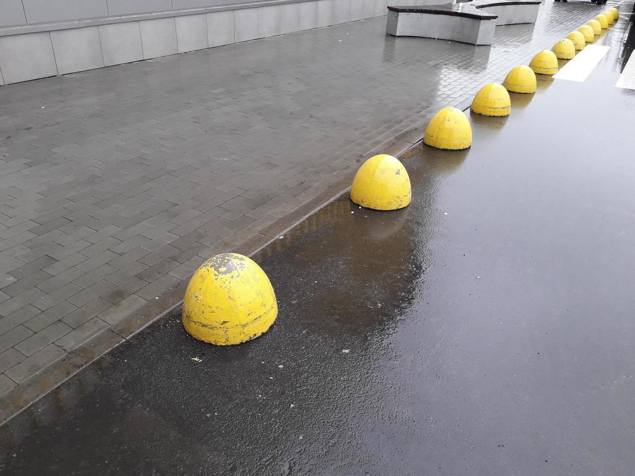 gelbe Begrenzer auf der Straße für ein Auto aus Beton foto