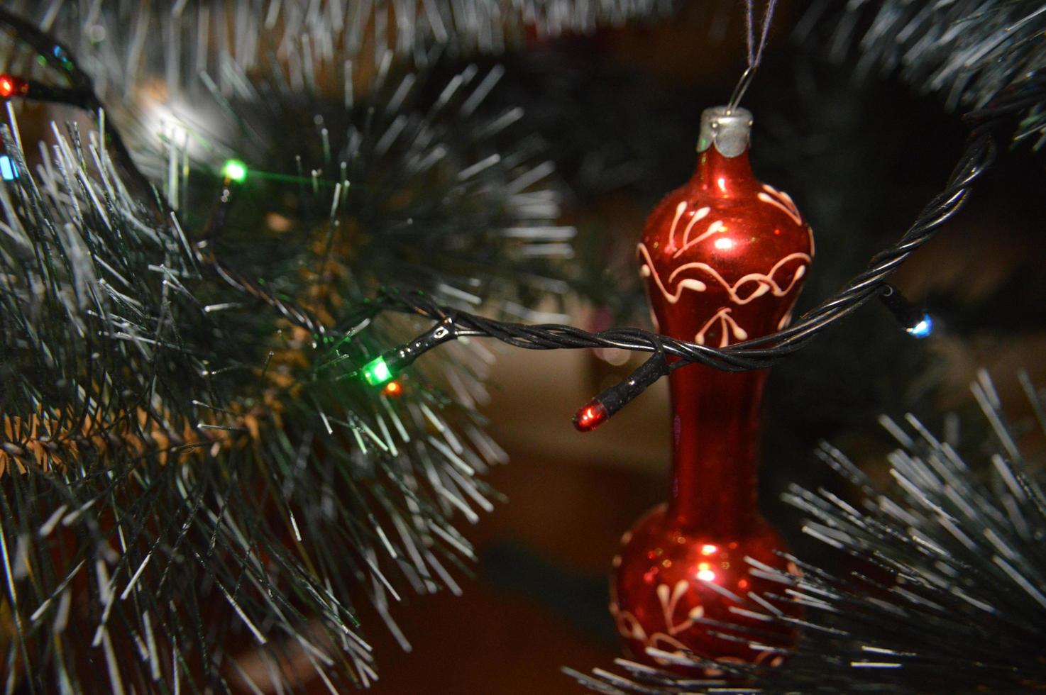 Weihnachtsbaum mit Spielzeug und leuchtenden Girlanden zu Hause und im Bürohintergrund foto