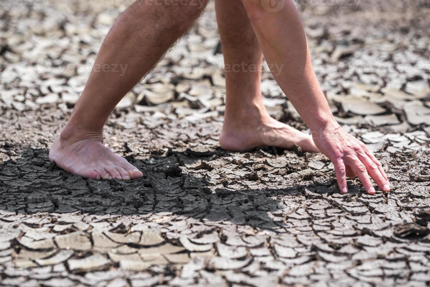 nackte Füße einer Person auf trockenem Boden ohne Pflanzen aus nächster Nähe foto