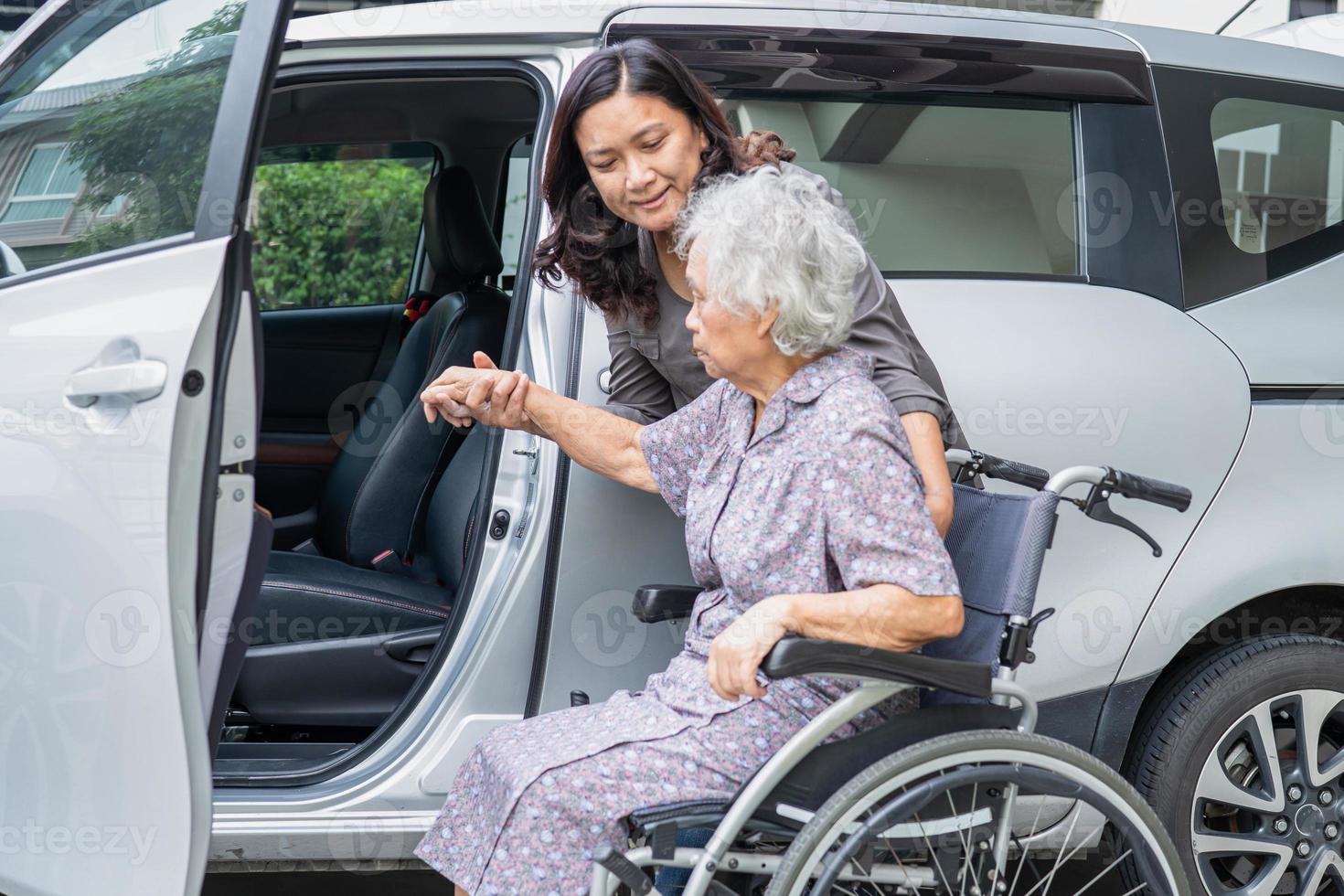 helfen und unterstützen Sie asiatische Senioren oder ältere Frauen, die im Rollstuhl sitzen, bereiten Sie sich darauf vor, zu ihrem Auto zu gelangen, gesundes, starkes medizinisches Konzept foto