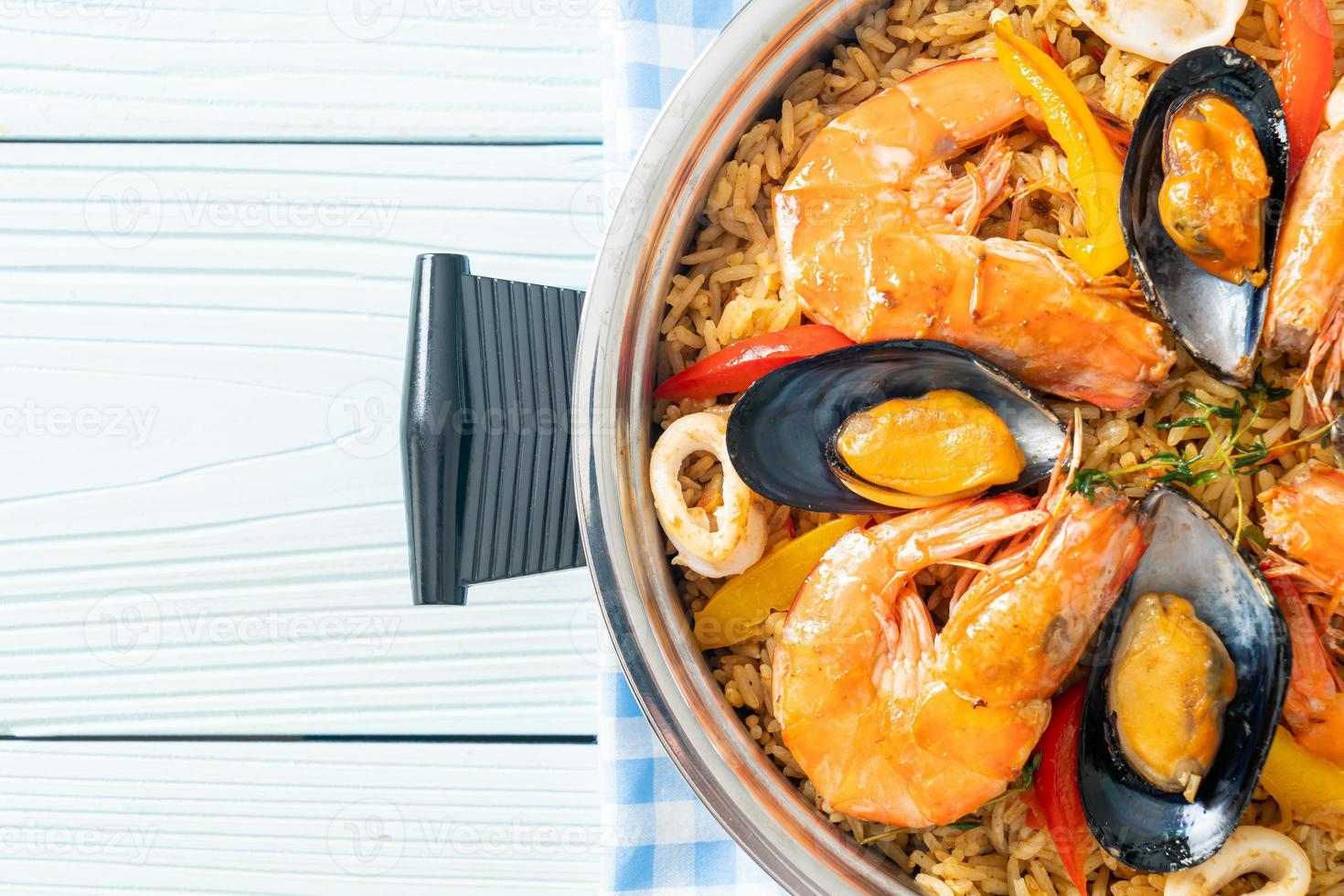 Meeresfrüchte-Paella mit Garnelen, Venusmuscheln, Miesmuscheln auf Safranreis foto