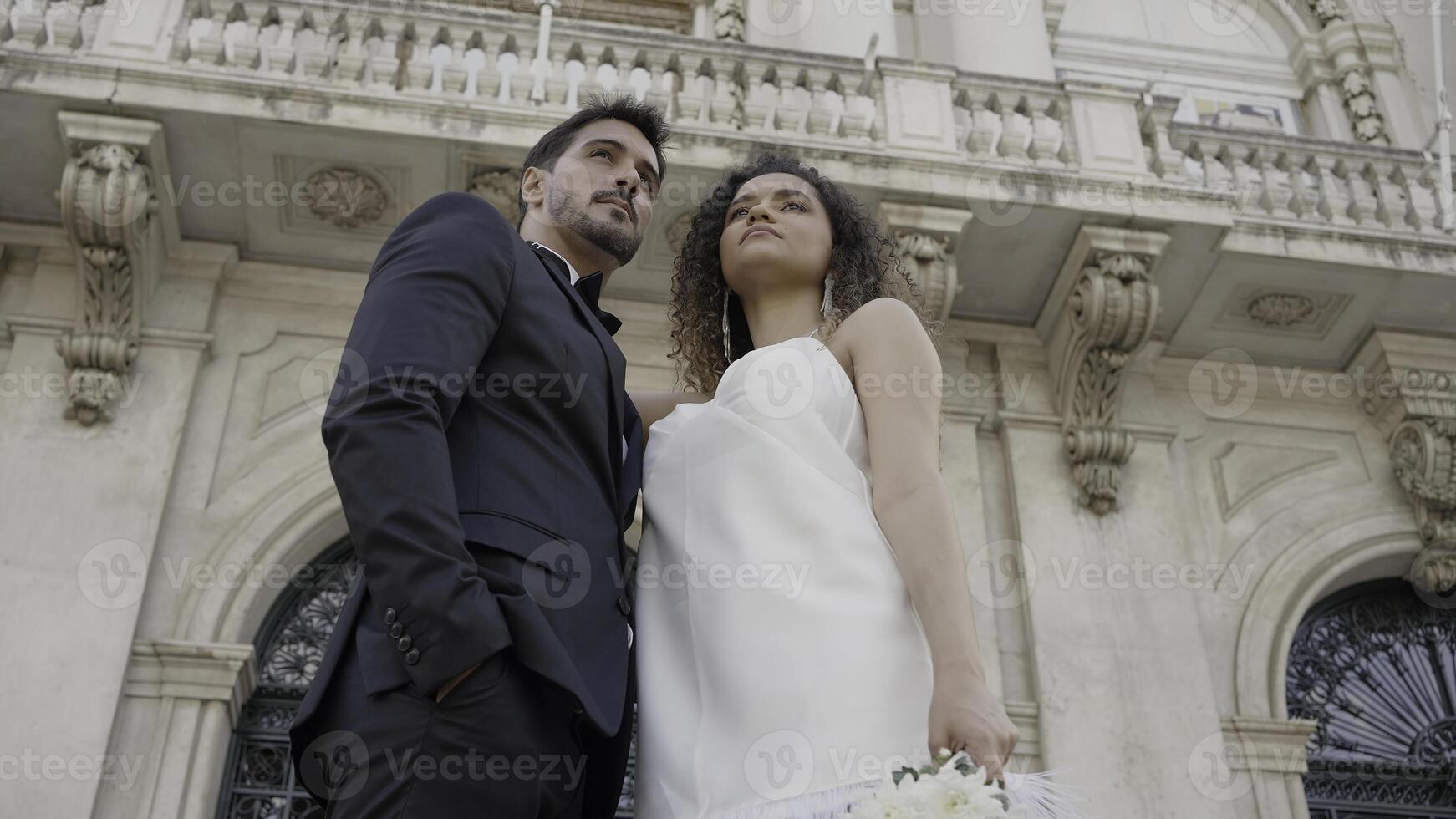 Hochzeit Paare posieren auf das Straße. Aktion. Jungvermählten im modisch Hochzeit Kostüme posieren süß auf das Straße im Sommer- Wetter. foto