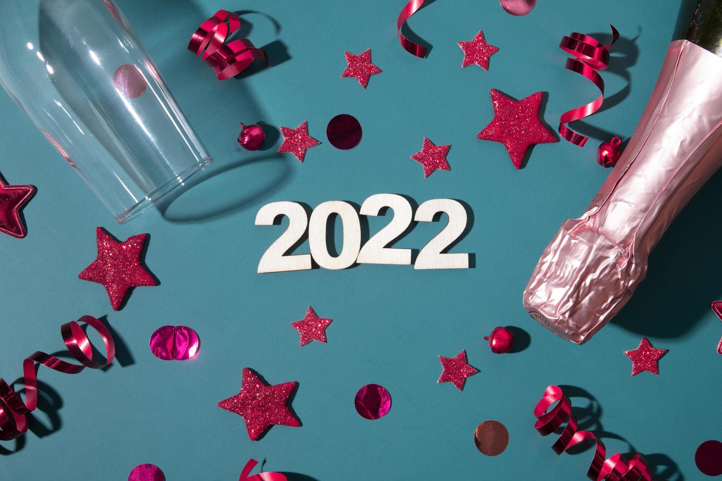 frohe weihnachten 2022 neujahr flach mit champagner, glas und sternen, luftschlangen foto