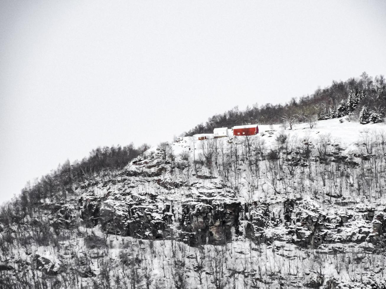 einsames rotes haus auf dem berg im winter in norwegen. foto