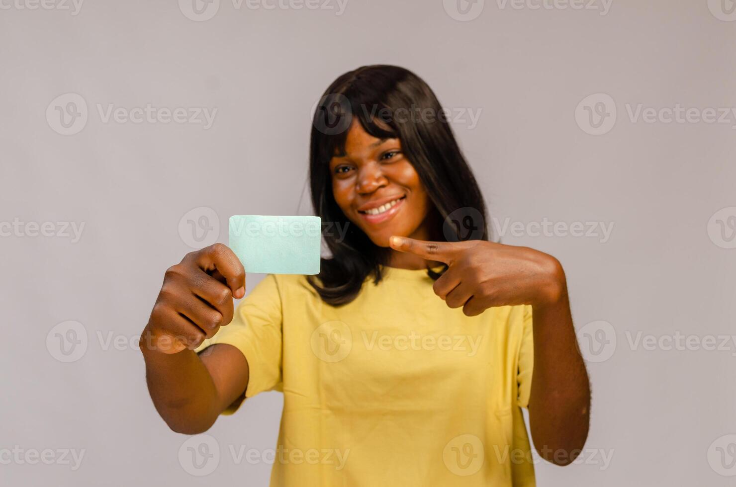 Frau hält ein leer Geschäft Karte aus im Vorderseite von ihr lächelnd Gesicht. foto