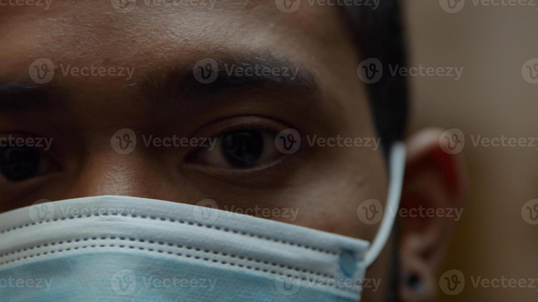 extreme Nahaufnahme des schwarzen Mannes mit Gesichtsmaske, Augen, die in Kamera schauen foto