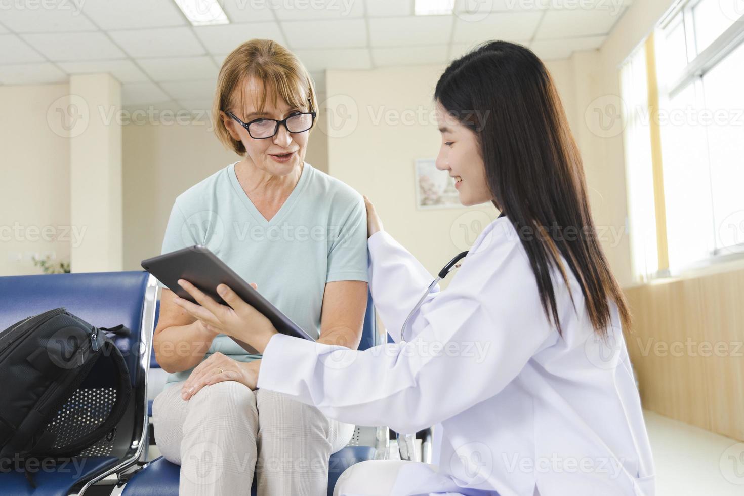 Ärztin berät die alte Patientin über ein Tablet im Krankenhaus. foto