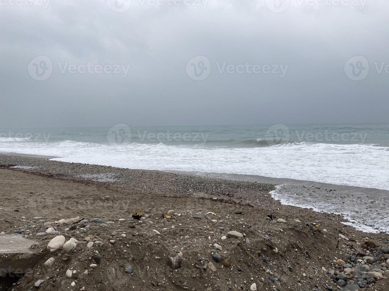 das turbulent Meer Stürme das Ufer von Sand gemischt mit Kieselsteine foto