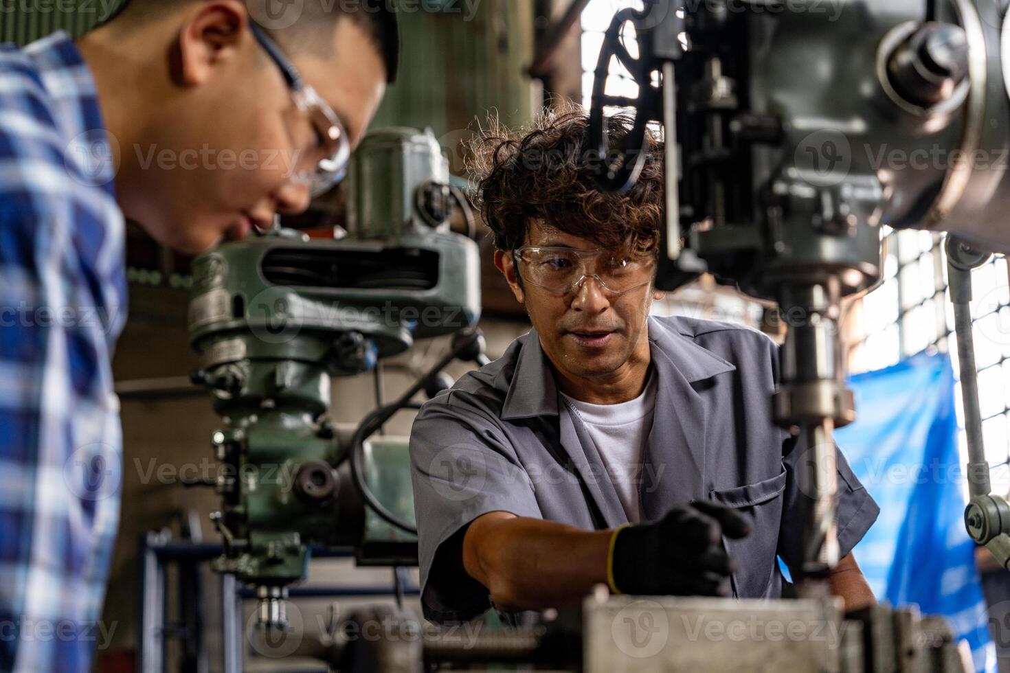 asiatisch Arbeiter im Produktion Pflanze Bohren beim Maschine. Fachmann Arbeiter in der Nähe von Bohren Maschine auf Fabrik. Fertigstellung Metall Arbeiten intern Stahl Oberfläche auf Drehbank Schleifer Maschine mit fliegend Funken. foto