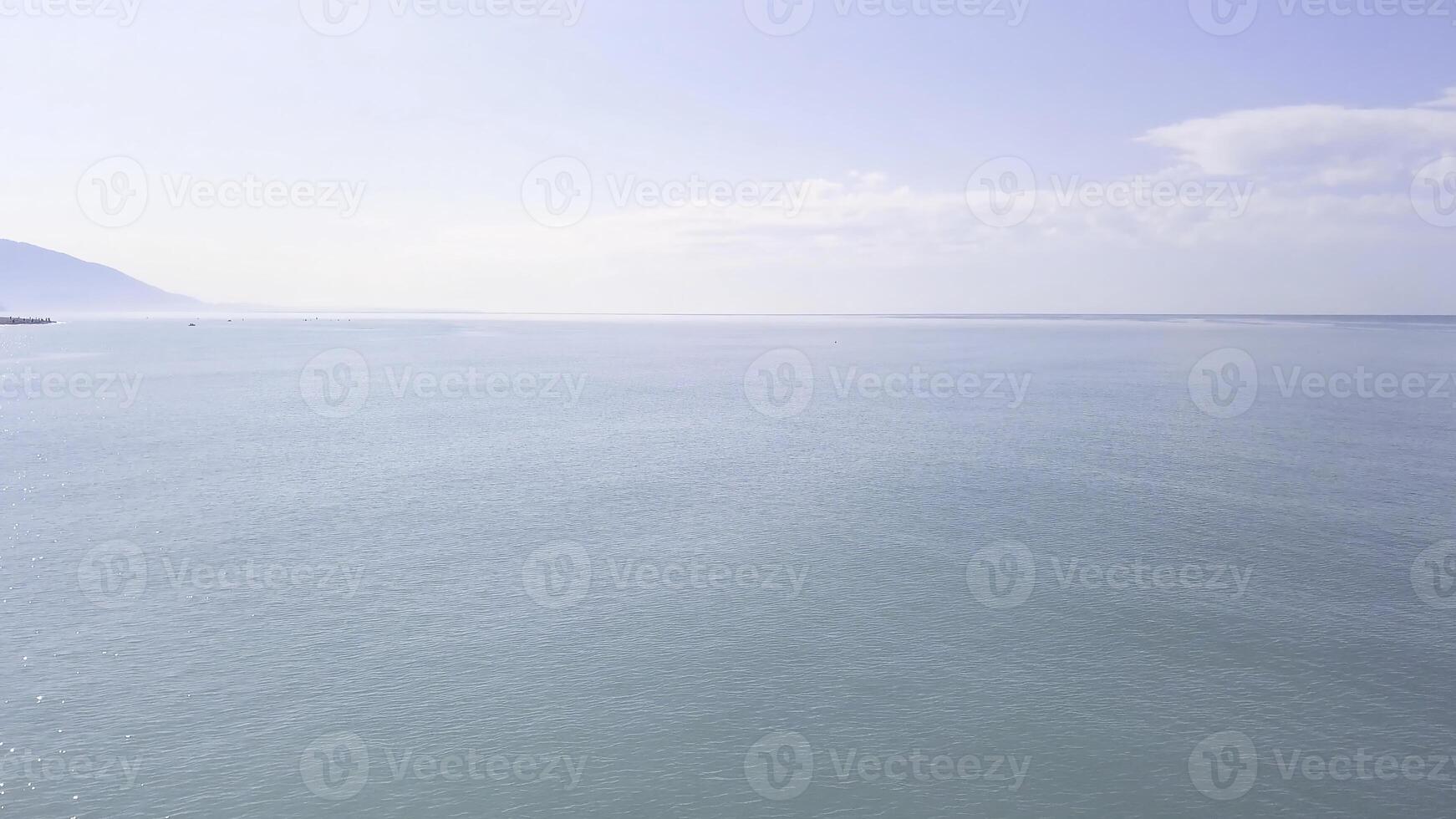 Antenne Drohne Aussicht von ein Mann üben Stand oben Paddel oder sup im tropisch exotisch Meer. Video. fliegend Über das Türkis Ruhe Meer und ein Mann Stehen auf ein sup Tafel auf Berge und wolkig Himmel Hintergrund. foto