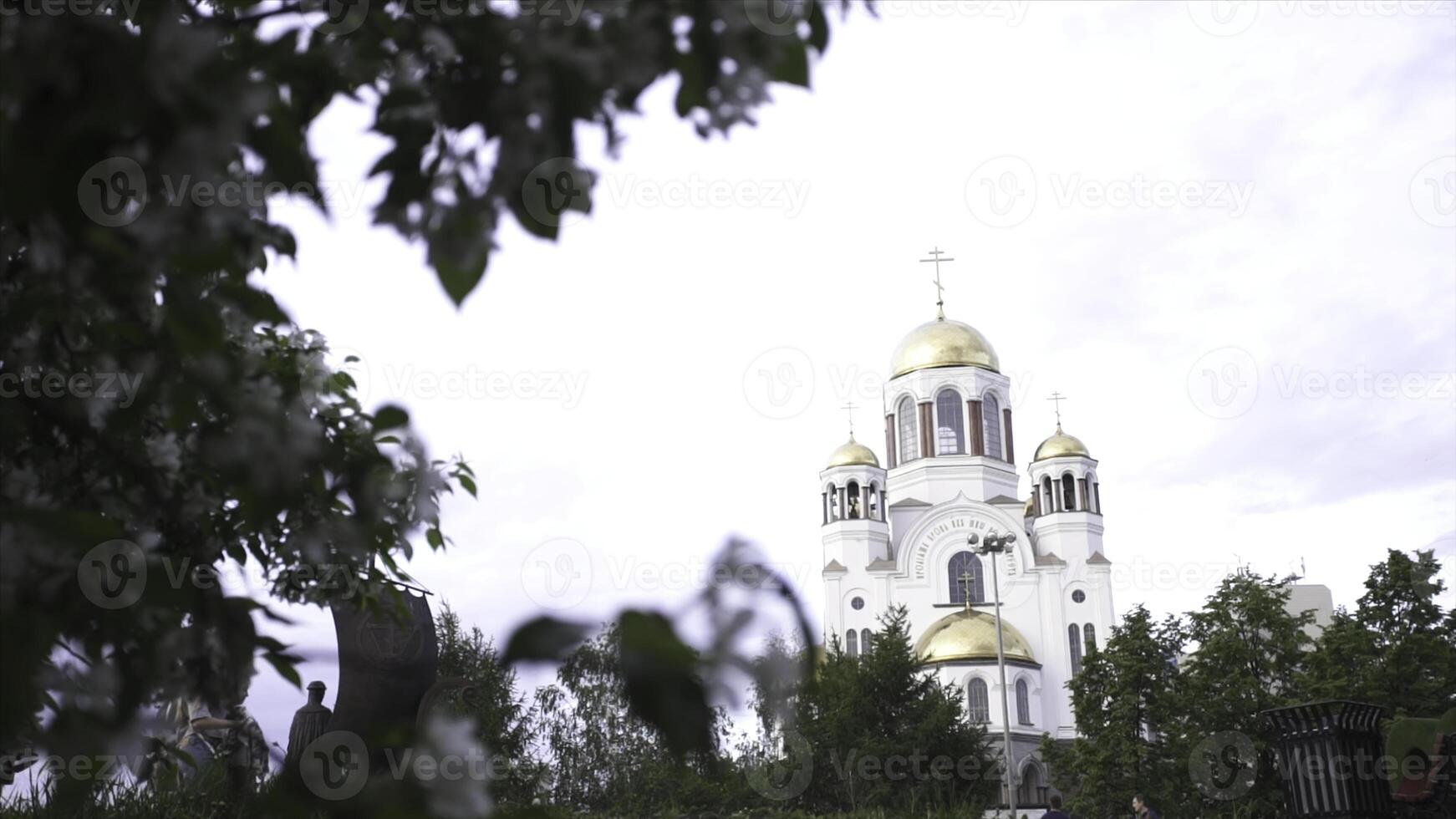 schließen oben zum ein Apfel Baum Ast mit Weiß Blumen und das schön Kirche hinter Es. Lager Filmaufnahme. das Kuppel von das orthodox Kirche umgeben durch blühen Apfel Bäume. foto