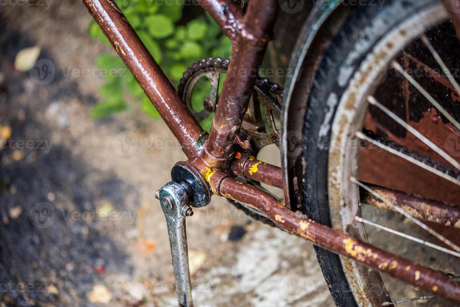 alte, verfallene braune Fahrradnahaufnahme mit selektivem Fokus und Unschärfe nach Regen foto