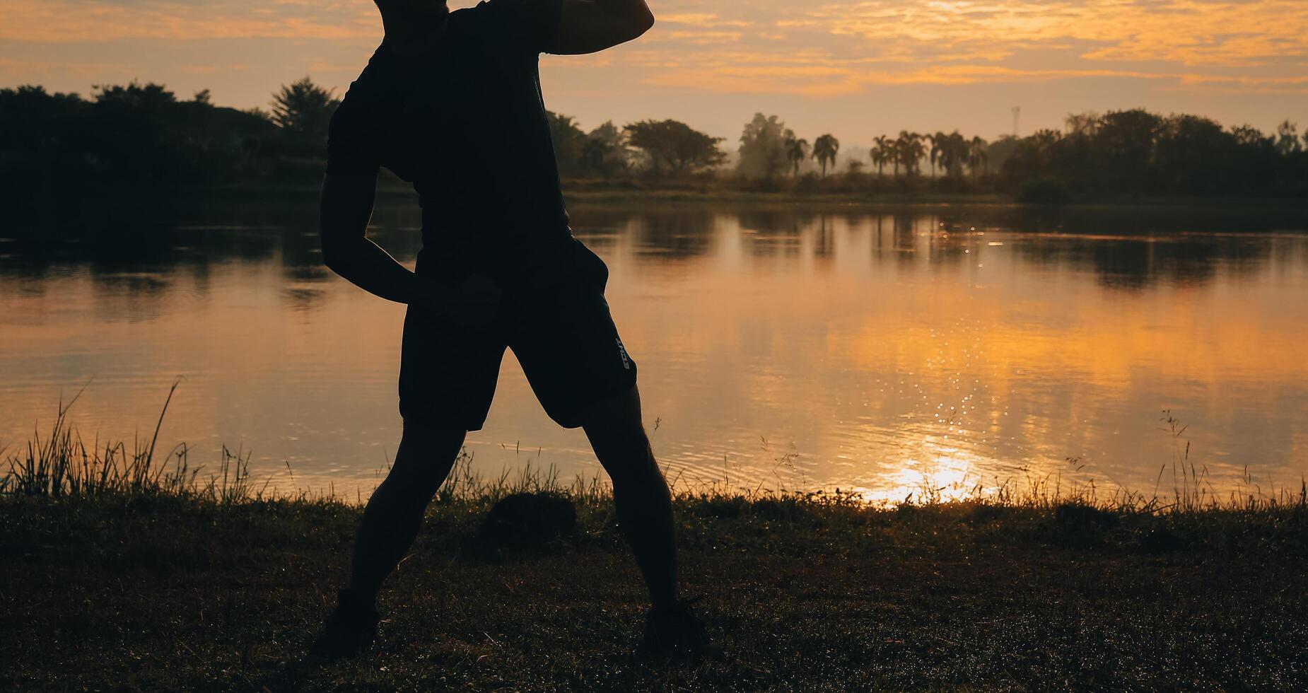 zurück Aussicht Silhouette von ein Läufer Mann Laufen auf das Strand beim Sonnenuntergang mit Sonne im das Hintergrund foto