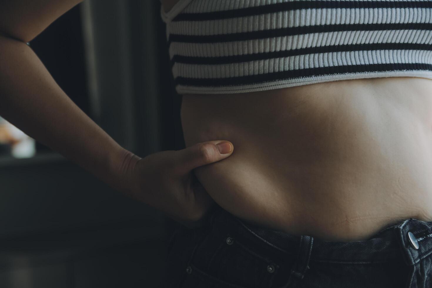 Frauen Körper Fett Bauch. fettleibig Frau Hand halten übermäßig Bauch fett. Diät Lebensstil Konzept zu reduzieren Bauch und gestalten oben gesund Bauch Muskel. foto