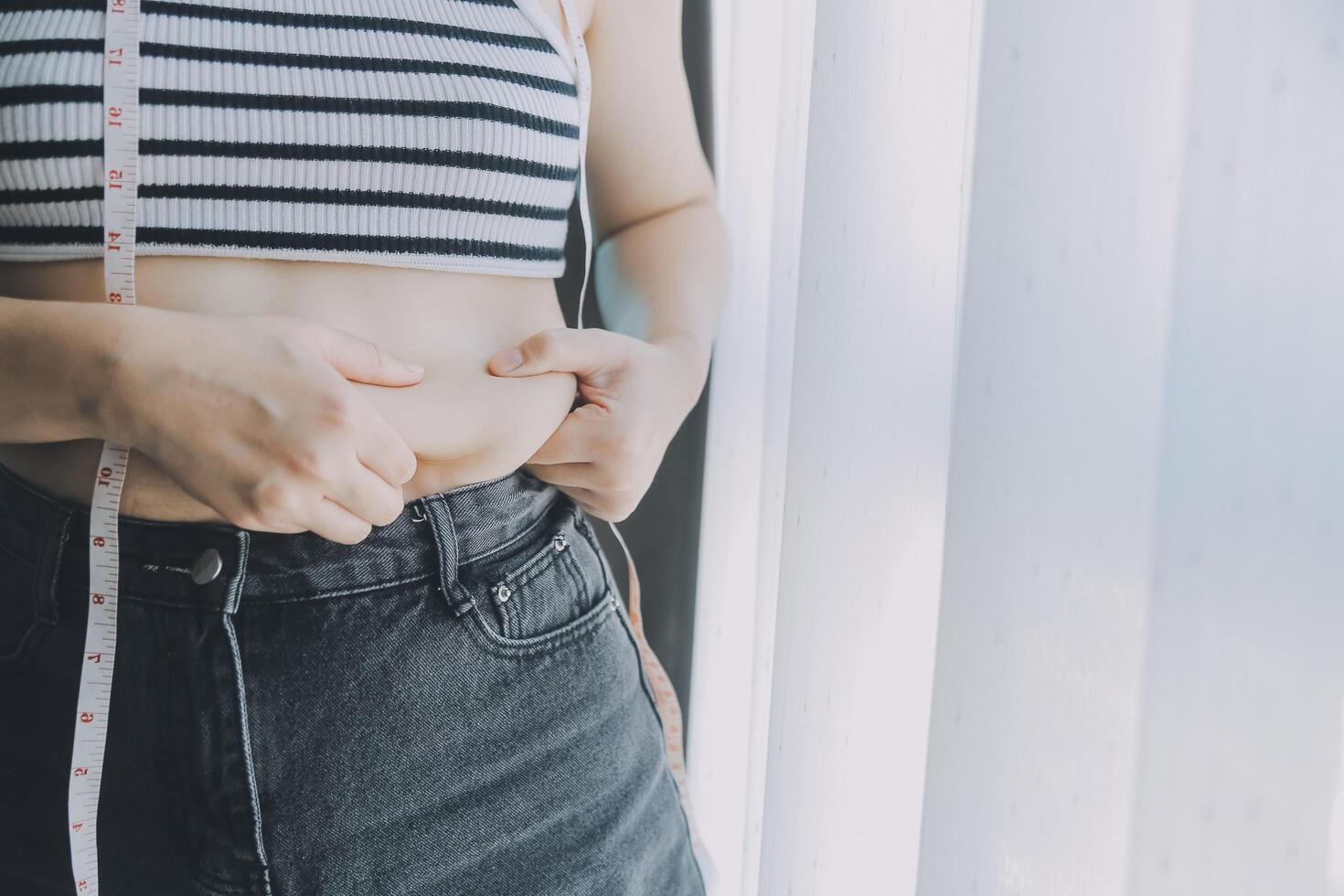 Frauen Körper Fett Bauch. fettleibig Frau Hand halten übermäßig Bauch fett. Diät Lebensstil Konzept zu reduzieren Bauch und gestalten oben gesund Bauch Muskel. foto