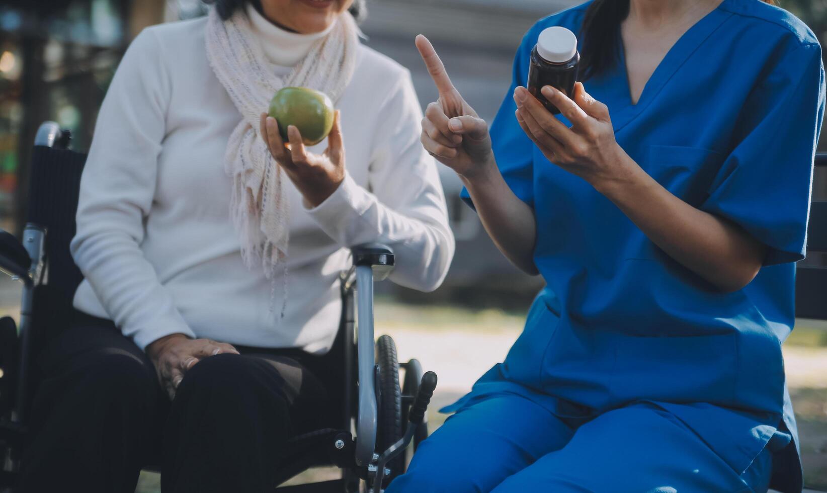 Krankenschwester mit Alten Mann im Rollstuhl beim Park foto