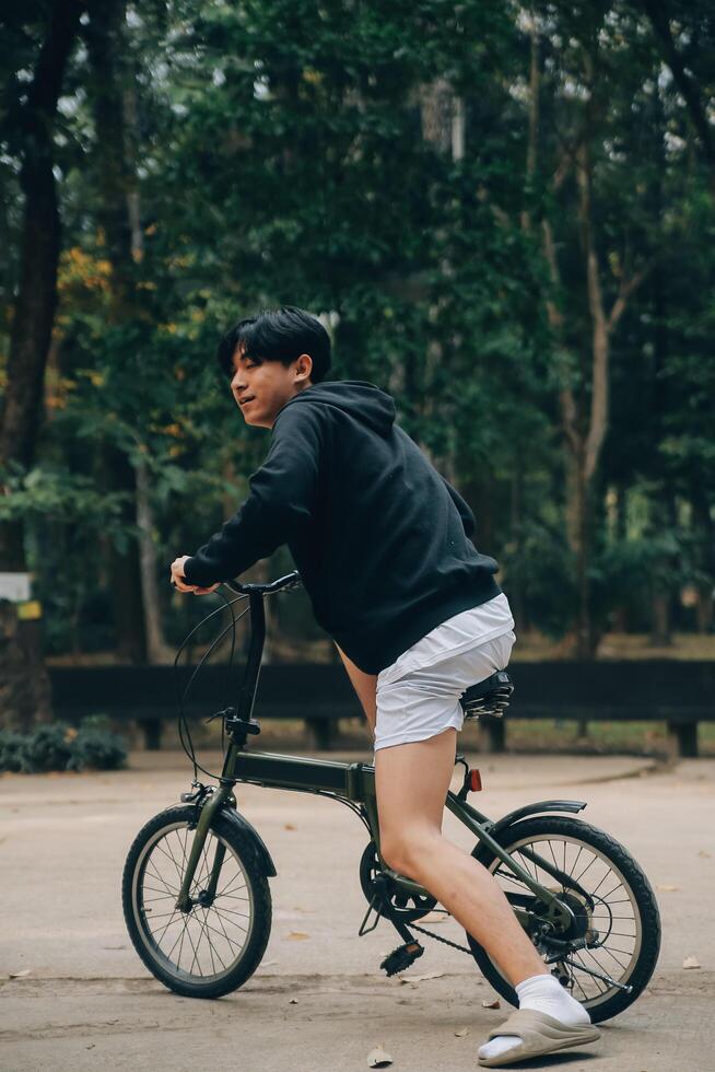 gut aussehend glücklich jung Mann mit Fahrrad auf ein Stadt Straße, aktiv Lebensstil, Menschen Konzept foto