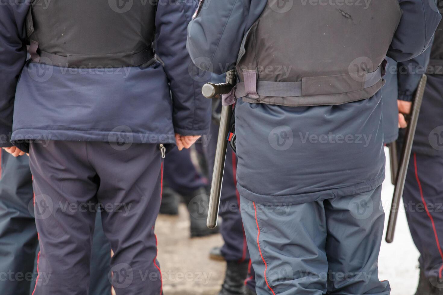 russischer polizist mit schwarzem tonfa-schlagstock aus gummi, der an seinem gürtel hängt foto