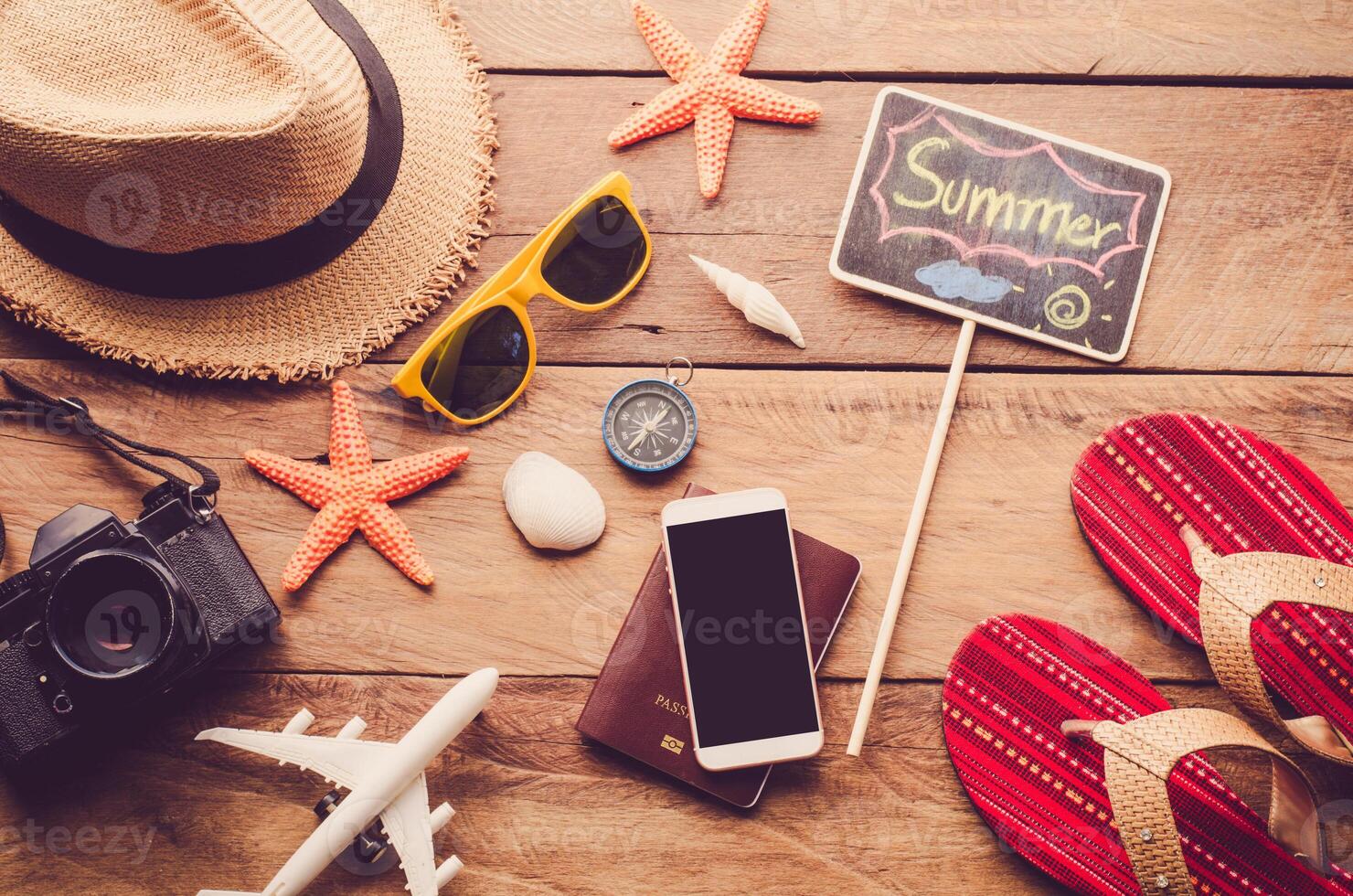 Meer Reise Zubehör ein Hut, Sonnenbrille, Kamera. platziert auf hölzern mit Wort Sommer- auf Tafel foto