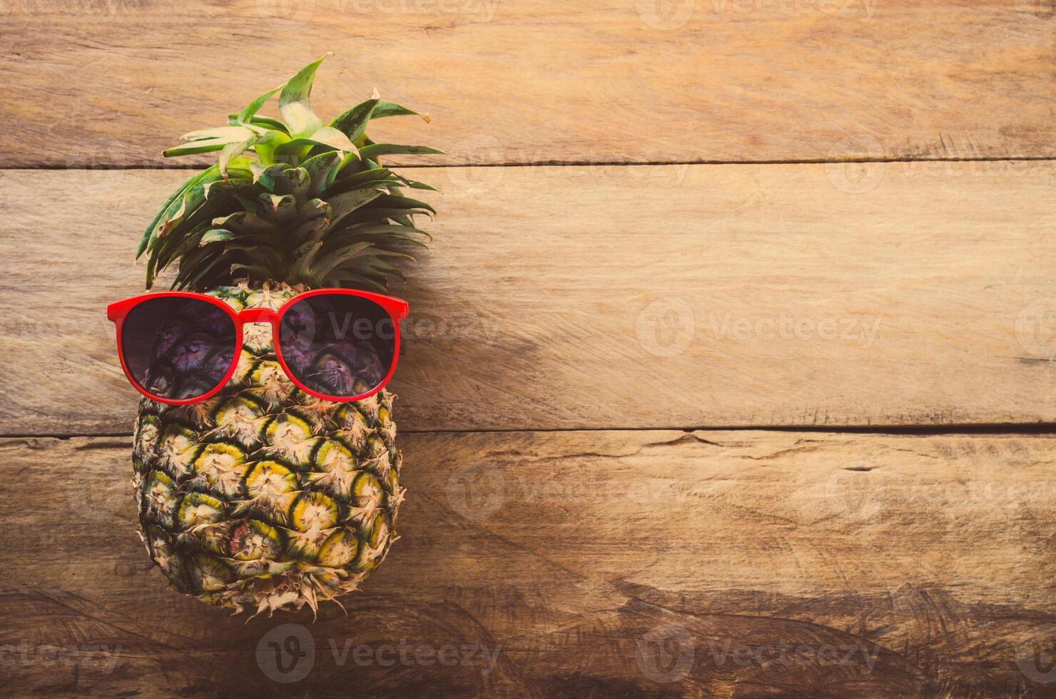 Ananas Sonnenbrille ruhen auf das hölzern Fußboden Konzept Reise. foto